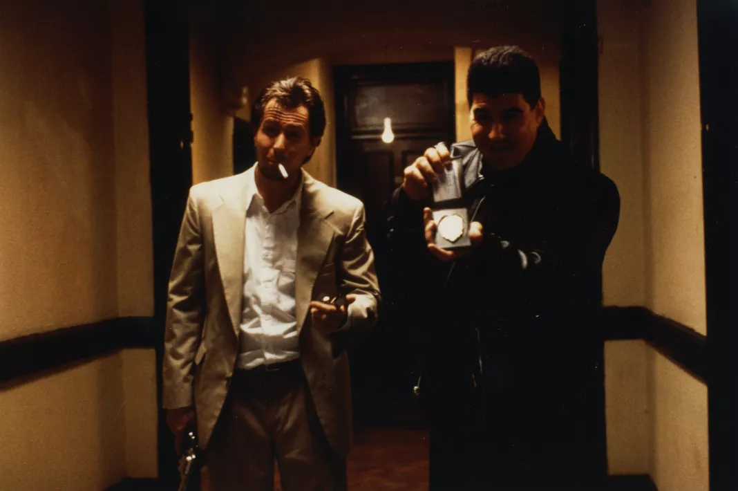 Gary Oldman nei panni di Stansfield sulla soglia di una porta con un altro agente