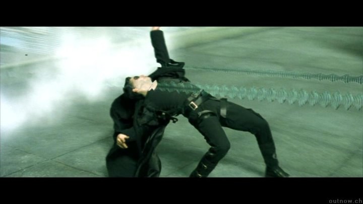 Neo si piega all’indietro per evitare i proiettili sul tetto.