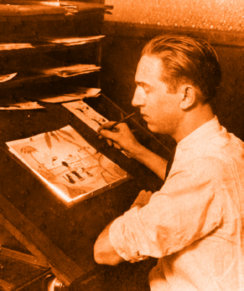 Il giovane Walt Disney seduto al tavolo da disegno