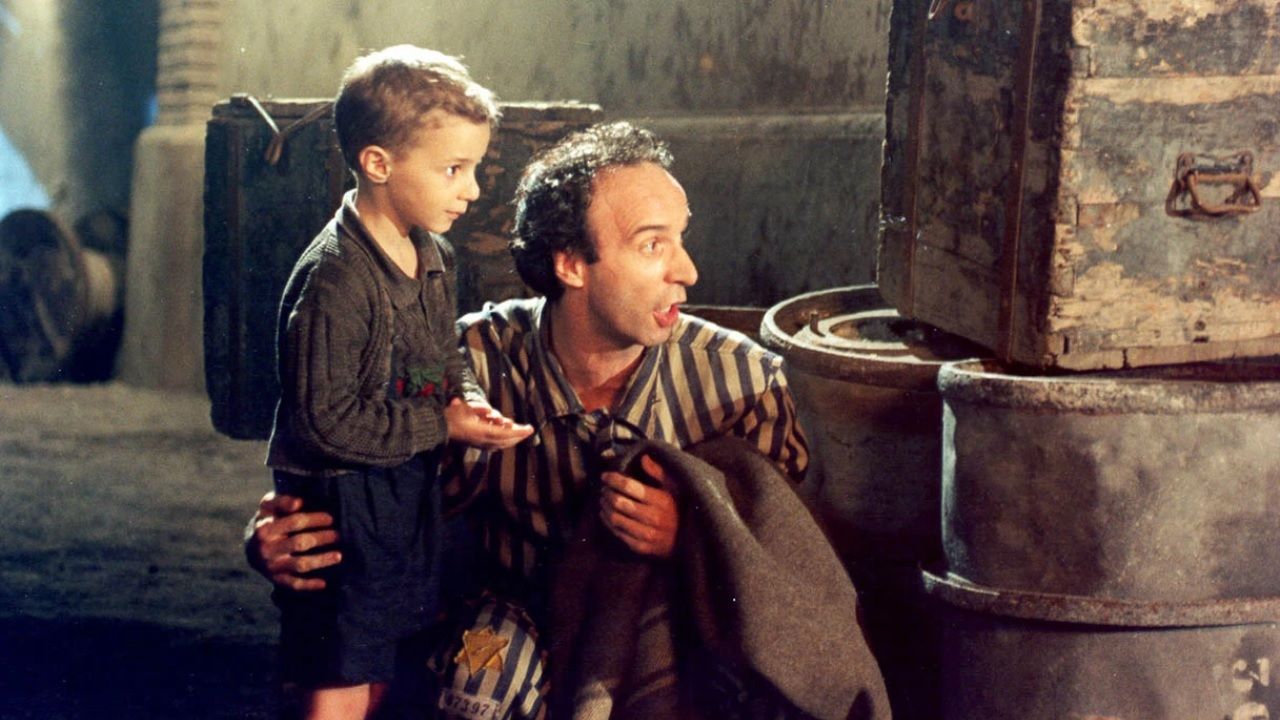 Guido e Giosuè nel campo: il padre trasforma la paura in un gioco.